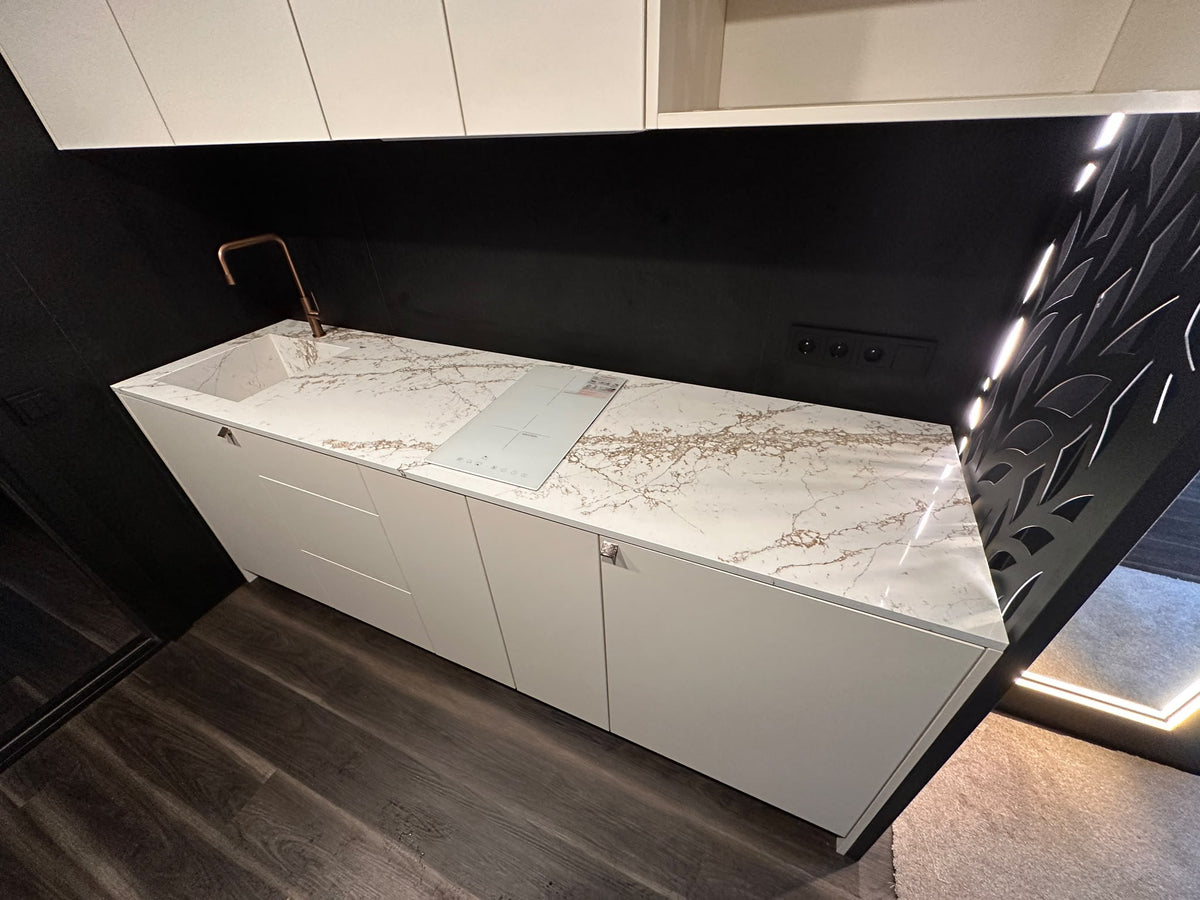 Polished TechniStone Bronze Coast countertop with an integrated sink and copper tap, fabricated by VideaStone